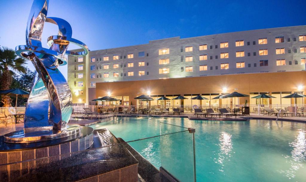 a large swimming pool with a large fountain in front of it at Hyatt Place Orlando/Lake Buena Vista in Orlando
