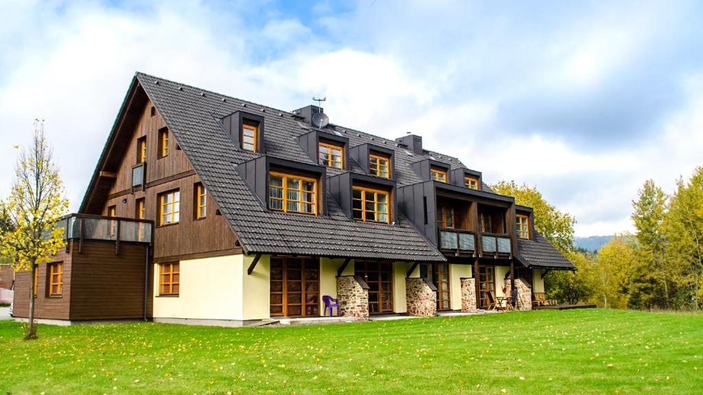 una casa con techo negro en un campo verde en Apartment Říčky V Orlických Horách, en Říčky