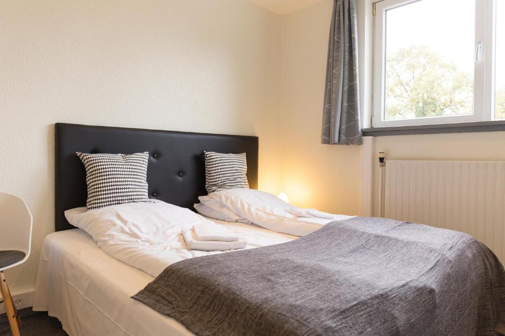 two beds sitting next to each other in a bedroom at Fjordlyst Hotel in Aabenraa