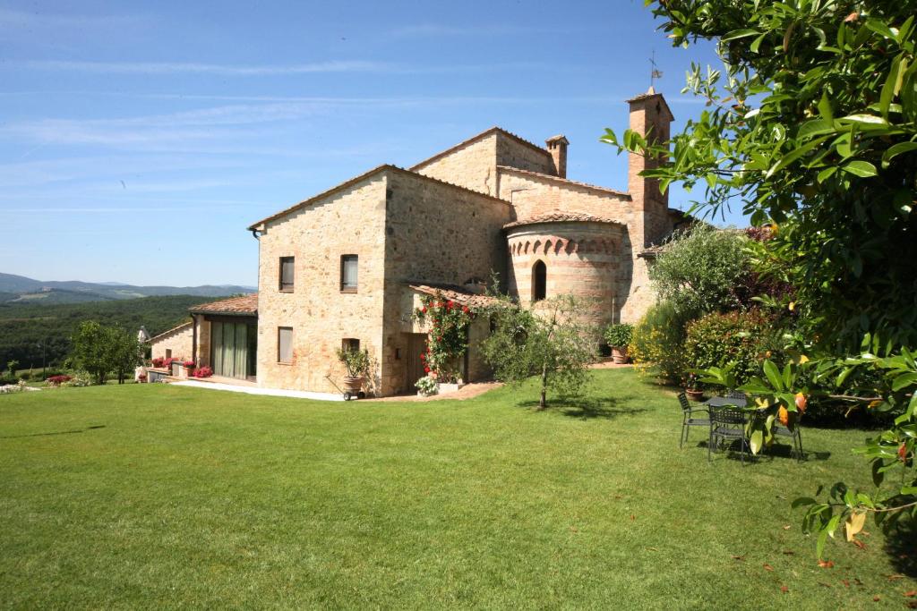 een extern uitzicht op een groot stenen huis met een tuin bij La Pieve di San Martino in Colle di Val d'Elsa