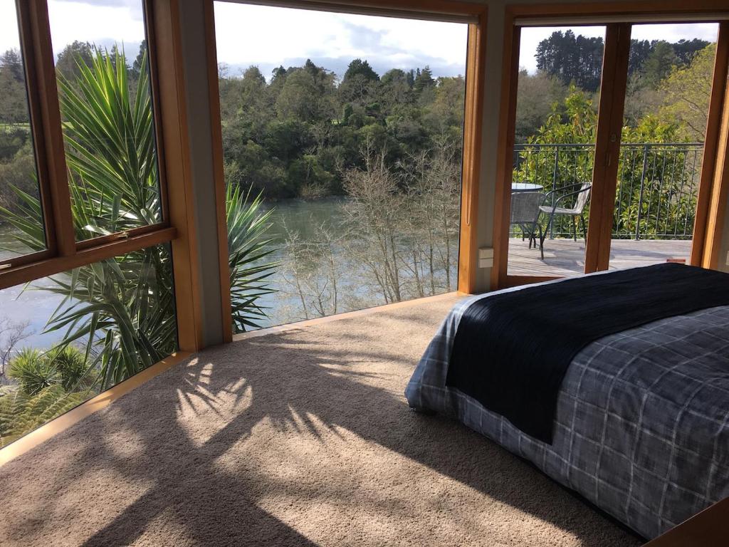 Schlafzimmer mit einem Bett und Blick auf das Wasser in der Unterkunft On The River in Hamilton