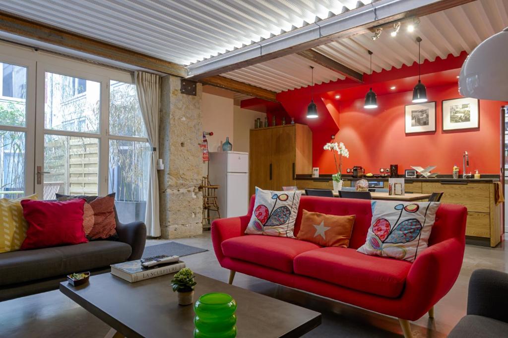 a living room with a red couch and a kitchen at L'Imprimerie in Lyon