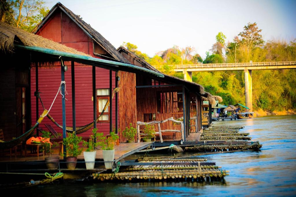 a building sitting on the side of a river at Boutique Raft Resort, River Kwai in Sai Yok