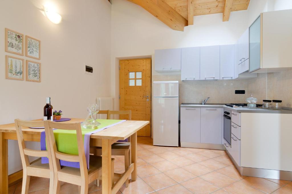 cocina con mesa de madera y electrodomésticos blancos en Apartment Valdisole, en Ossana