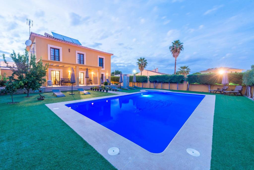 a swimming pool in front of a house at Finca Ca Nantonia in Sa Coma