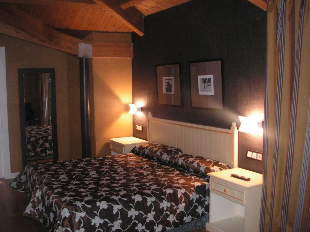 a bedroom with a bed with two night stands and two lamps at Hotel Iru-Bide in Lumbier