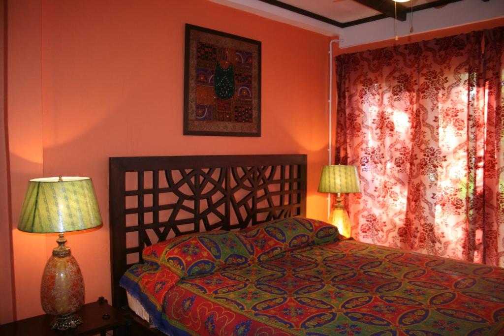 a bedroom with a bed and two lamps and a window at Baan Til Dao Pround Fah in Ban Na Sok