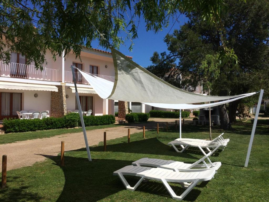 2 sillas y una hamaca frente a una casa en Villa Casita, Terrace & Pool, en Sant Martí d’Empúries