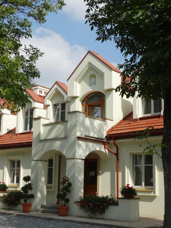 a white house with red roof at Pokoje Gościnne Dom św. Szymona in Kraków