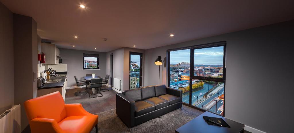 a living room with a couch and a view of a city at Luxury Apartments Newcastle in Newcastle upon Tyne