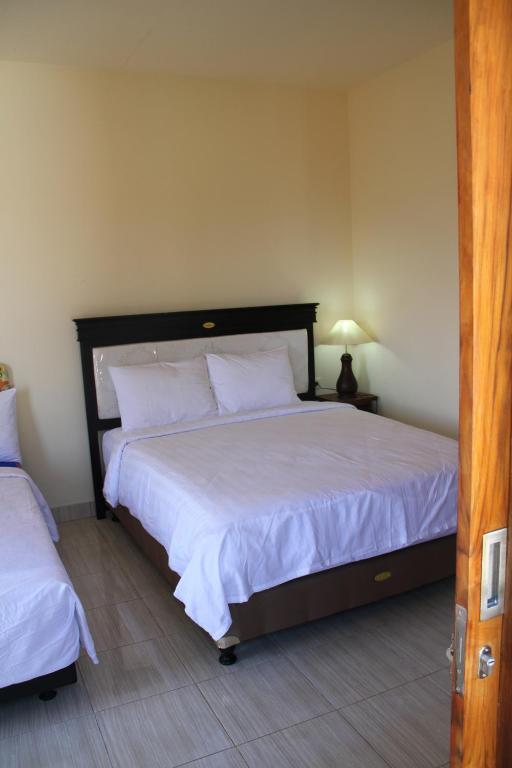 Postel nebo postele na pokoji v ubytování Adila Warung and Homestay