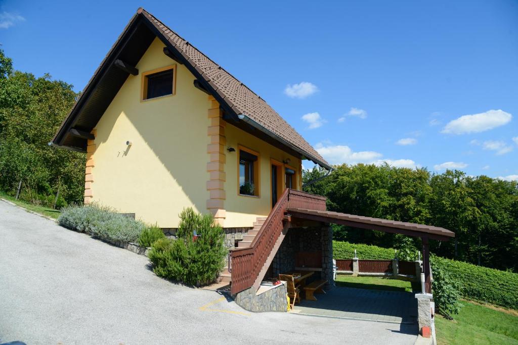 une petite maison avec une terrasse couverte et un escalier dans l'établissement Holiday Home Češnovar, à Raka