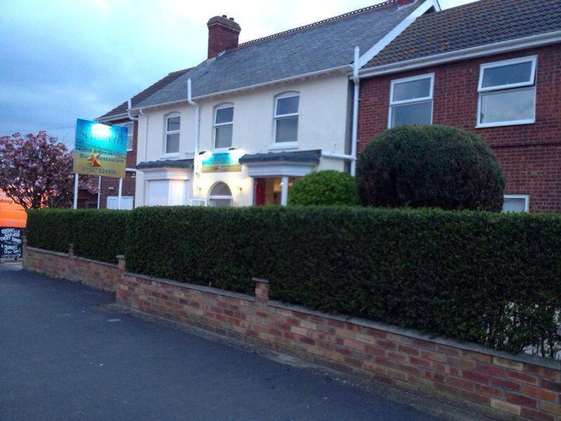 a house with a hedge in front of it at Seashells Beach Hotel in Sutton on Sea