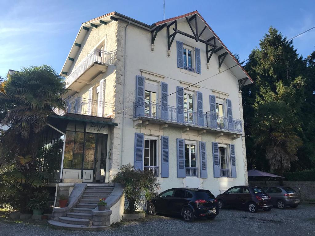 une maison avec deux voitures garées devant elle dans l'établissement Hôtel Montilleul - Villa Primrose, à Pau
