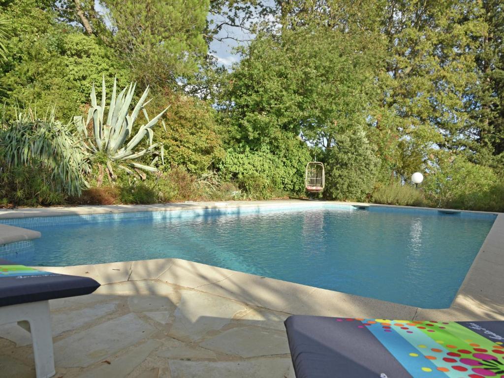 einen Pool in einem Garten mit einem Stuhl in der Unterkunft Quaint Villa in Fayence with Private Swimming Pool in Fayence