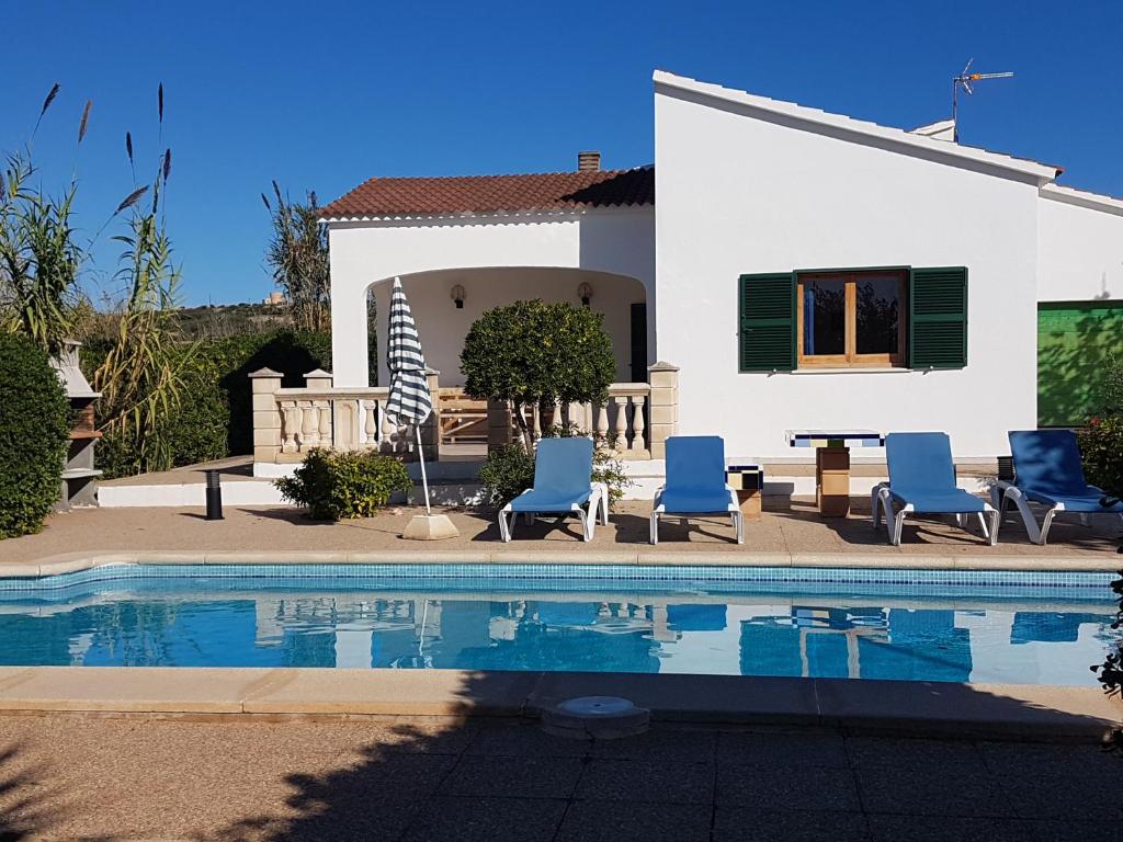 a villa with a swimming pool in front of a house at Villa Luz in Cala en Blanes