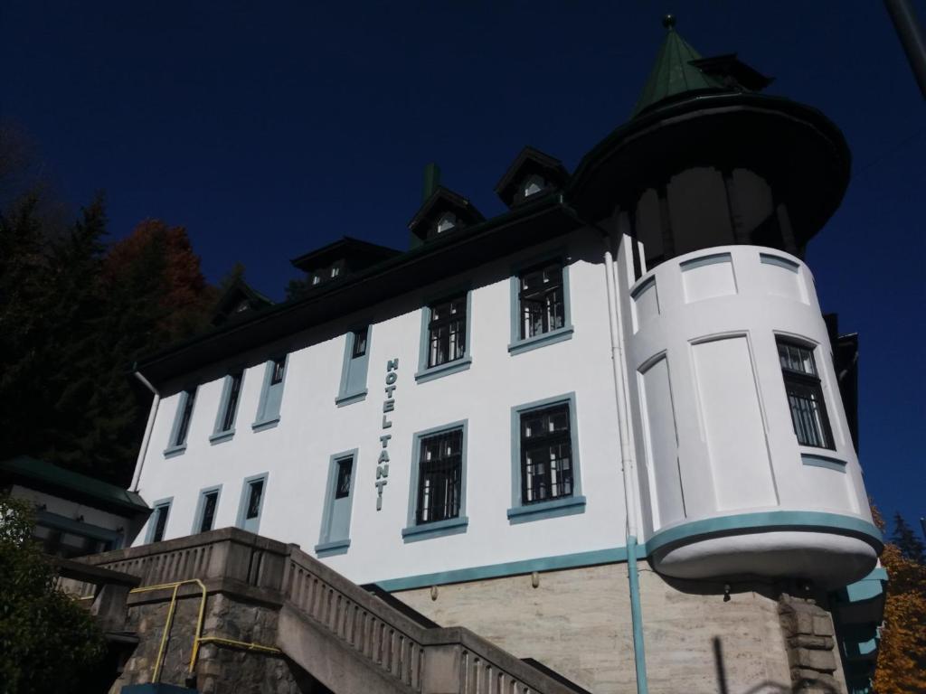 un bâtiment blanc avec un toit noir dans l'établissement Hotel Tantzi, à Sinaia