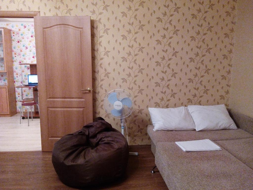 モスクワにあるApartment on Molodogvardeyskayaのソファ、枕、ファンが備わる客室です。