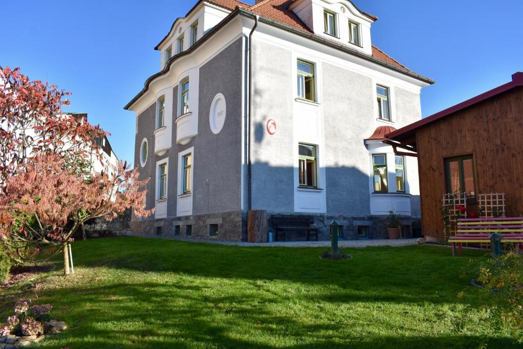 un grande edificio con un prato verde di fronte di 1st Republic Villa - Adults only a Cesky Krumlov