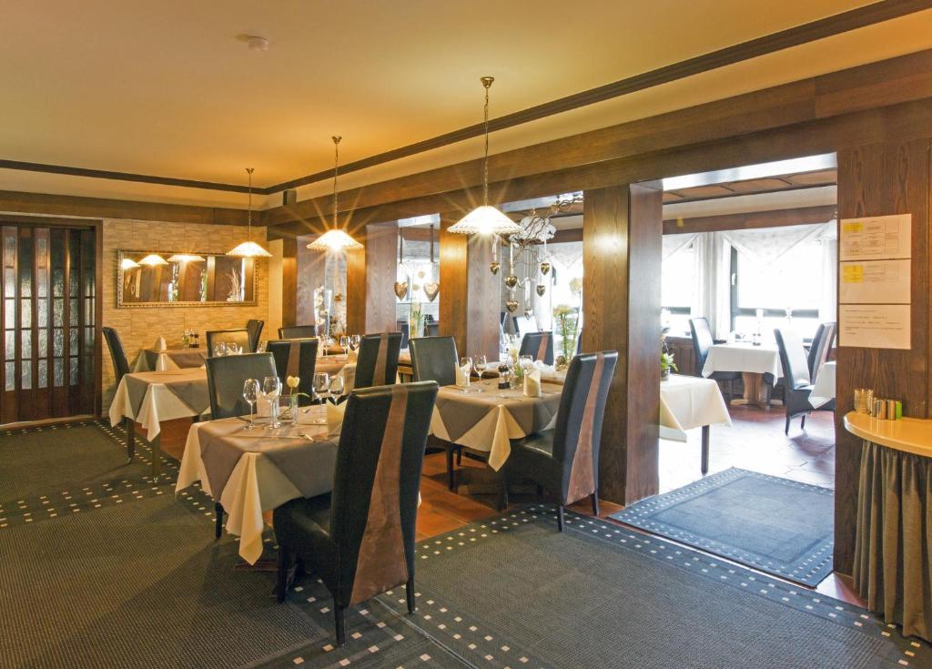 a restaurant with tables and chairs in a room at Hotel Kupper in Eppenbrunn