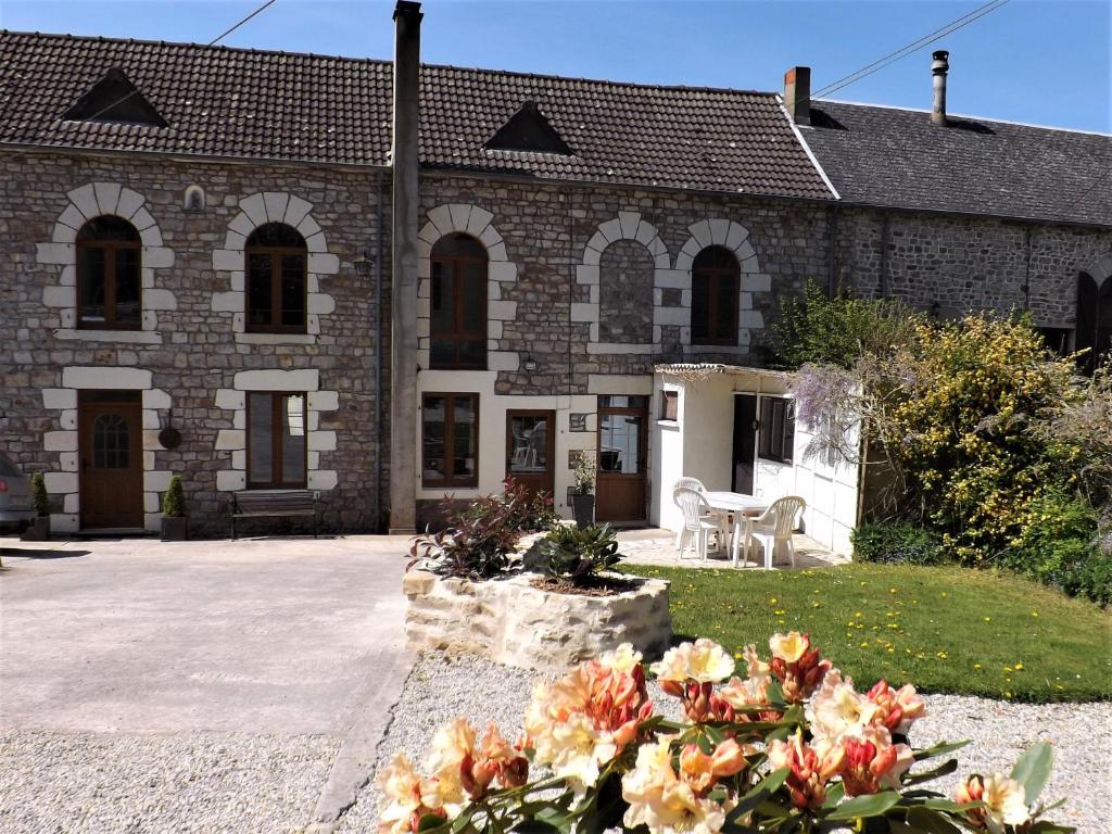 une maison en briques avec des fleurs devant elle dans l'établissement Tranquil Watermill, à Pré-en-Pail