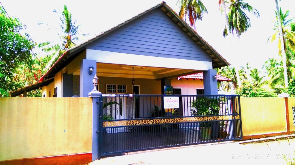 a house with a gate and a fence at Relaxs Homestay in Kota Bharu