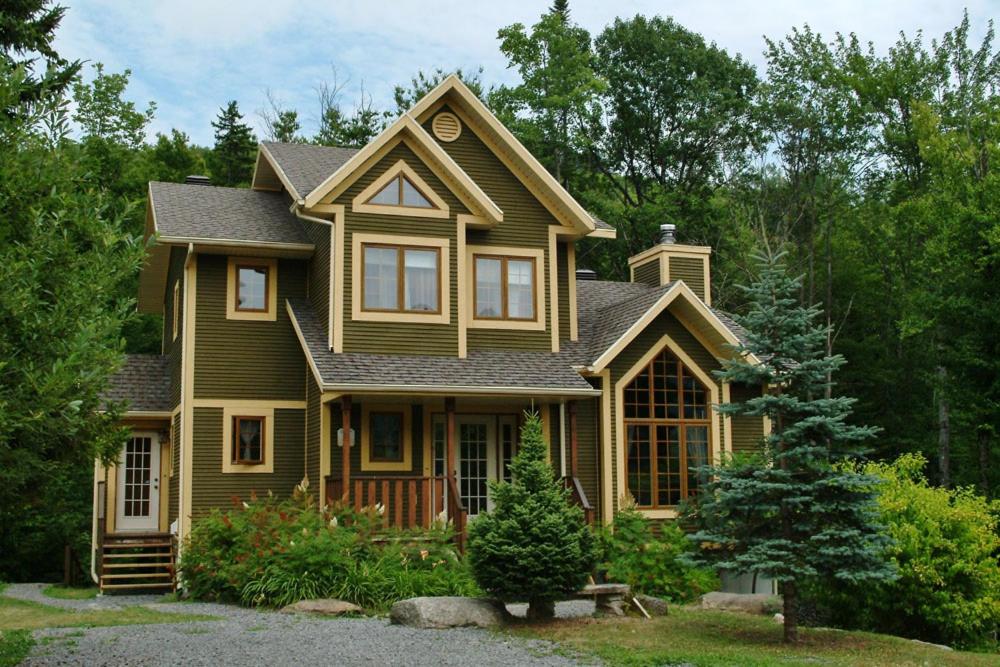 una casa marrón con techo de gambrel en Chalets Alpins- 15 Chemin des Skieurs, en Stoneham