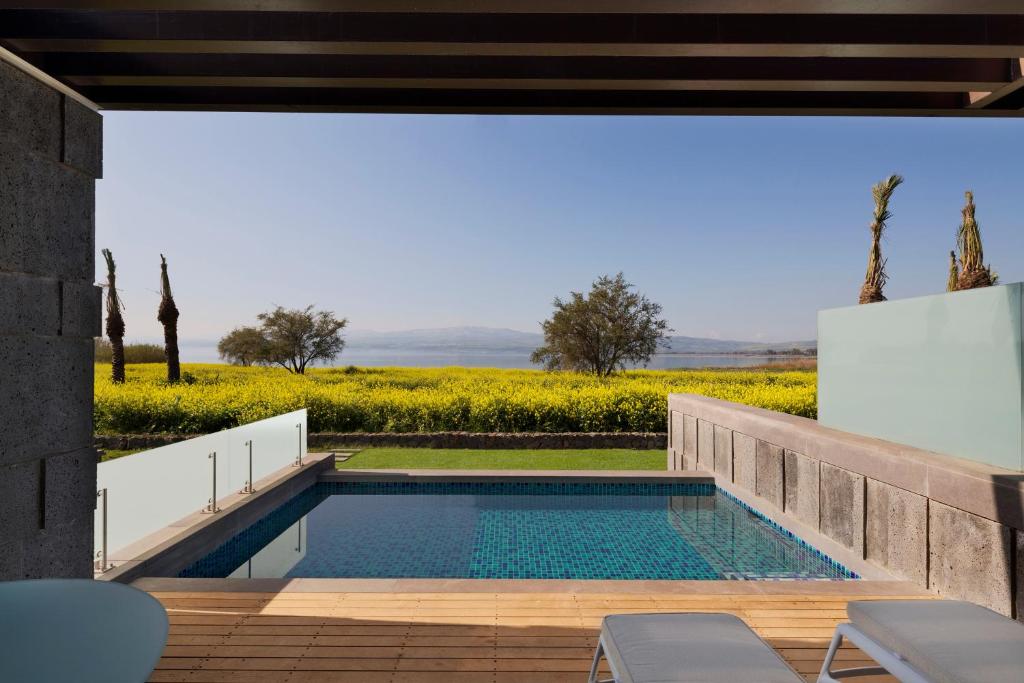 a swimming pool in a house with a view of a field at The Setai Sea Of Galilee in Ein Gev