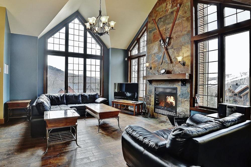 uma sala de estar com mobiliário de couro e uma lareira em Chalets Alpins 44 Chemin des Skieurs em Stoneham
