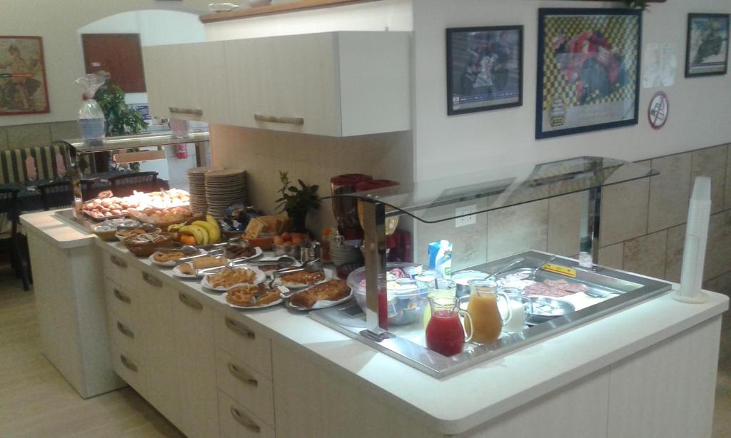 Eine Küchentheke mit einem Haufen Essen drauf. in der Unterkunft Hotel Aros in Rimini