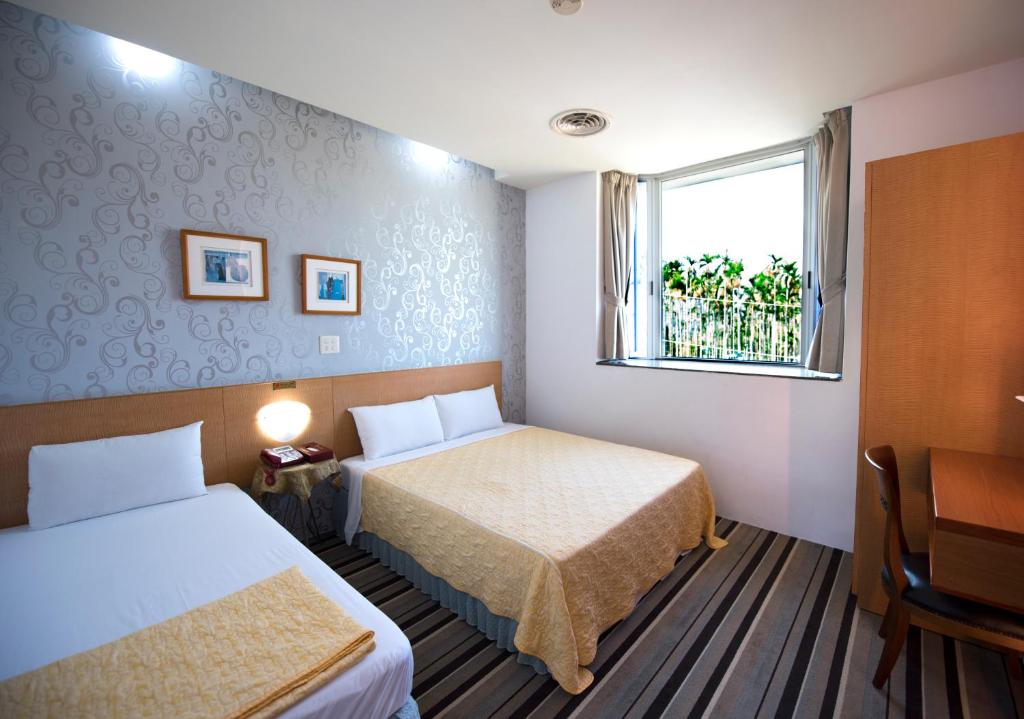 a hotel room with two beds and a window at Songyuan B&amp;B in Lugu Lake