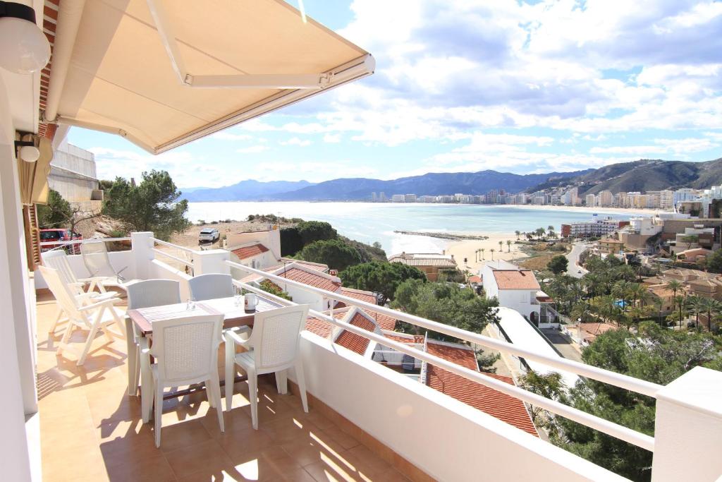 ファロ・デ・クリェラにあるChalet Apartamento Manoloのビーチの景色を望むバルコニー(白い椅子付)