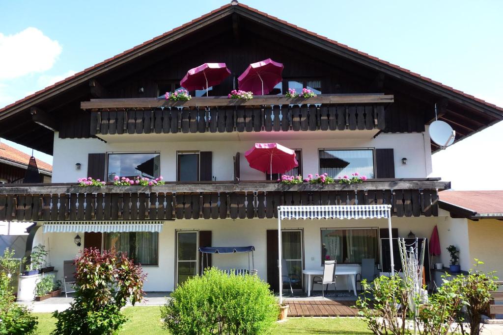 a house with a balcony with umbrellas on it at Gästehaus Aurikel 10 in Fischen