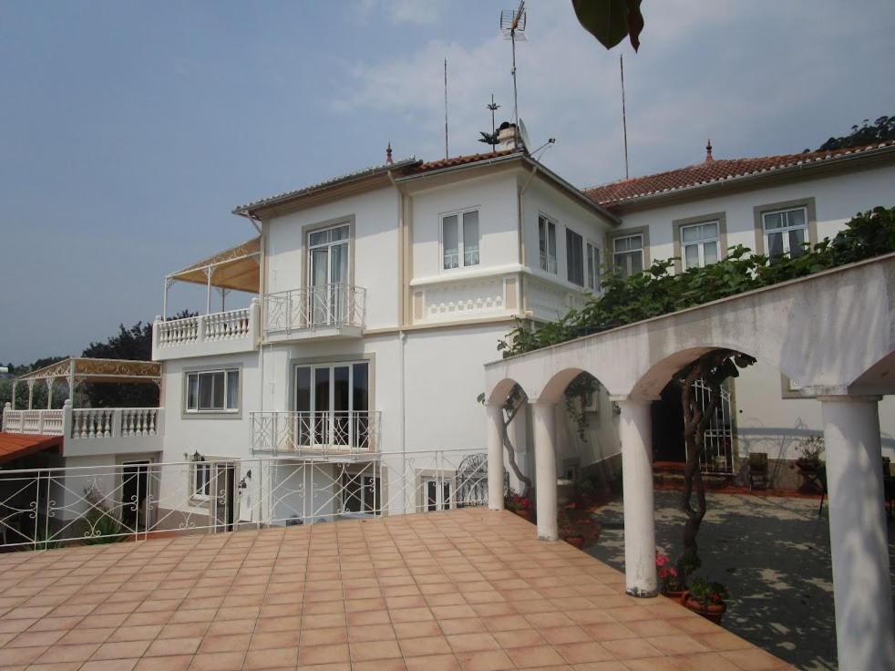 a large white building with a patio in front of it at Quinta Outeiro da Luz in Branca