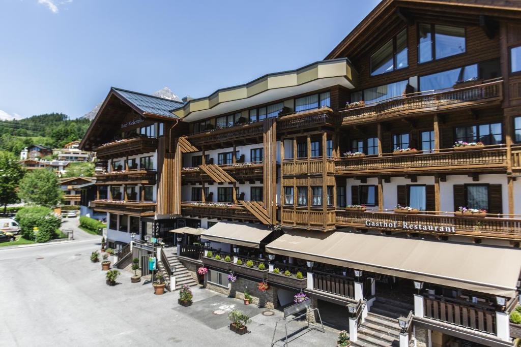 an apartment building with wooden balconies on a street at Hotel Niederreiter in Maria Alm am Steinernen Meer