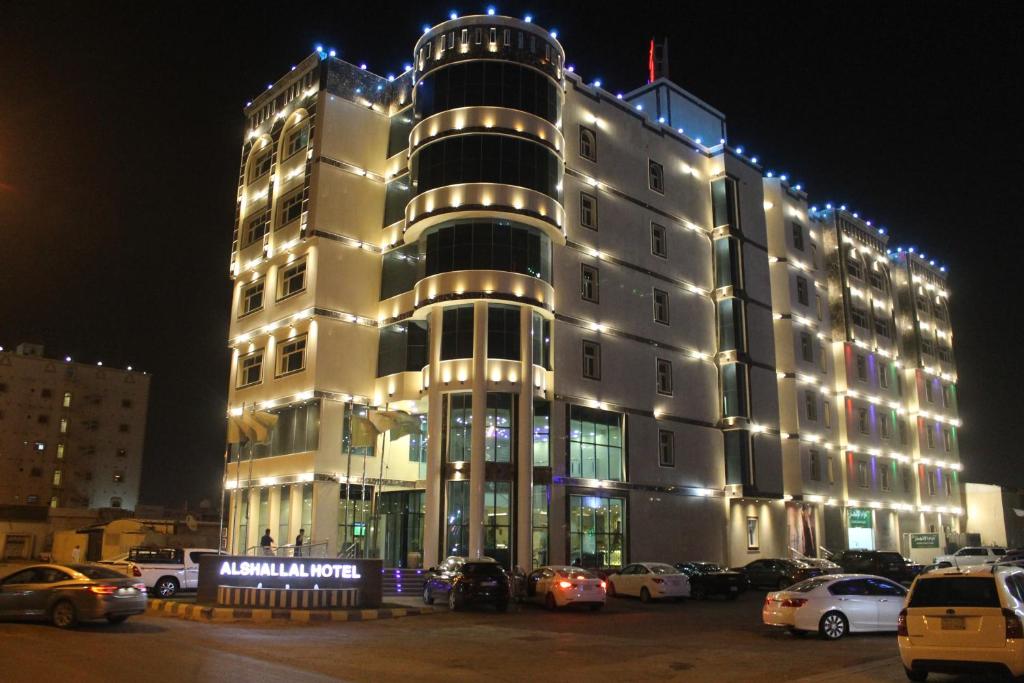 un grande edificio con auto parcheggiate di fronte di Rayat Al Shalal Hotel a Hafr Al Baten