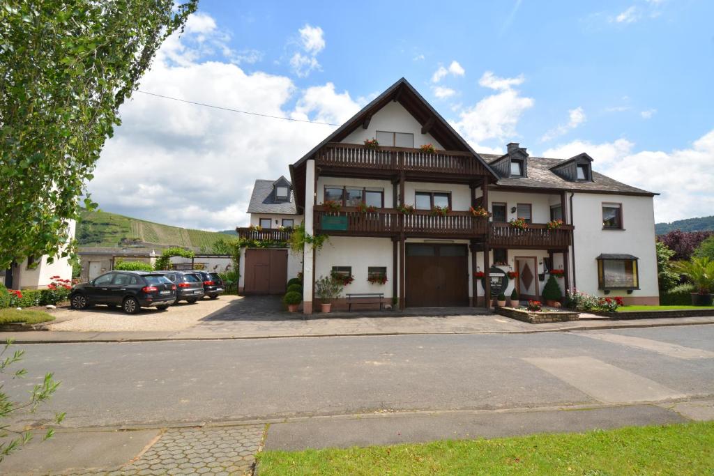 a large white house with a balcony at Weingut***Pension Günther Scholtes in Leiwen