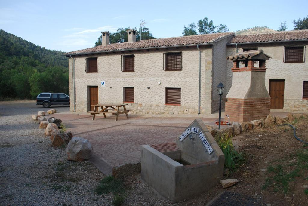 un edificio con una mesa de picnic delante de él en Fuente del Ciervo 1 en Arroyo Frío