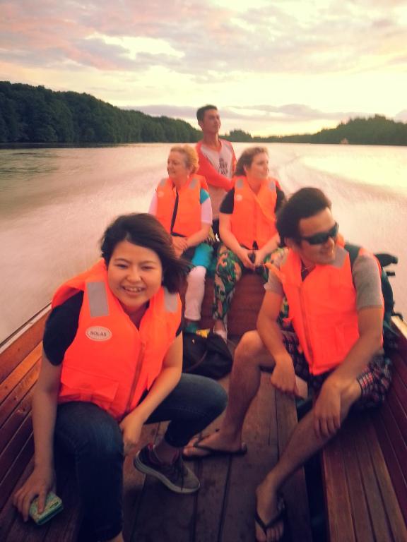 a group of people wearing life jackets sitting on a boat at Kunyit 7 Lodge in Bandar Seri Begawan