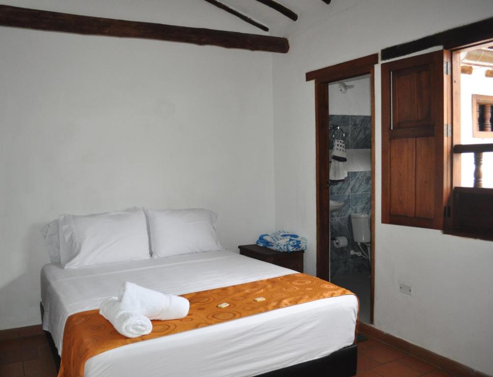 a bedroom with a bed with towels on it at Hospedaje Donde Lorenzo in Barichara