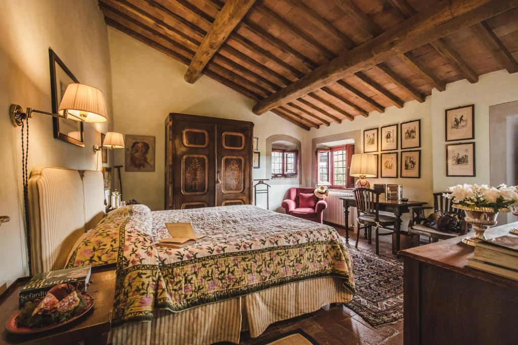 La Veronica Exclusive Chianti Resort في غريفي ان شنتي: غرفة نوم بسرير وطاولة في غرفة