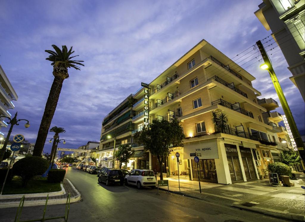 eine Stadtstraße mit einem Gebäude und einer Palme in der Unterkunft Lakonia Hotel in Sparta