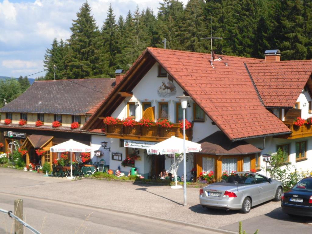 a building with red roofs and a car parked in front at Landgasthaus Gemsennest in Feldberg