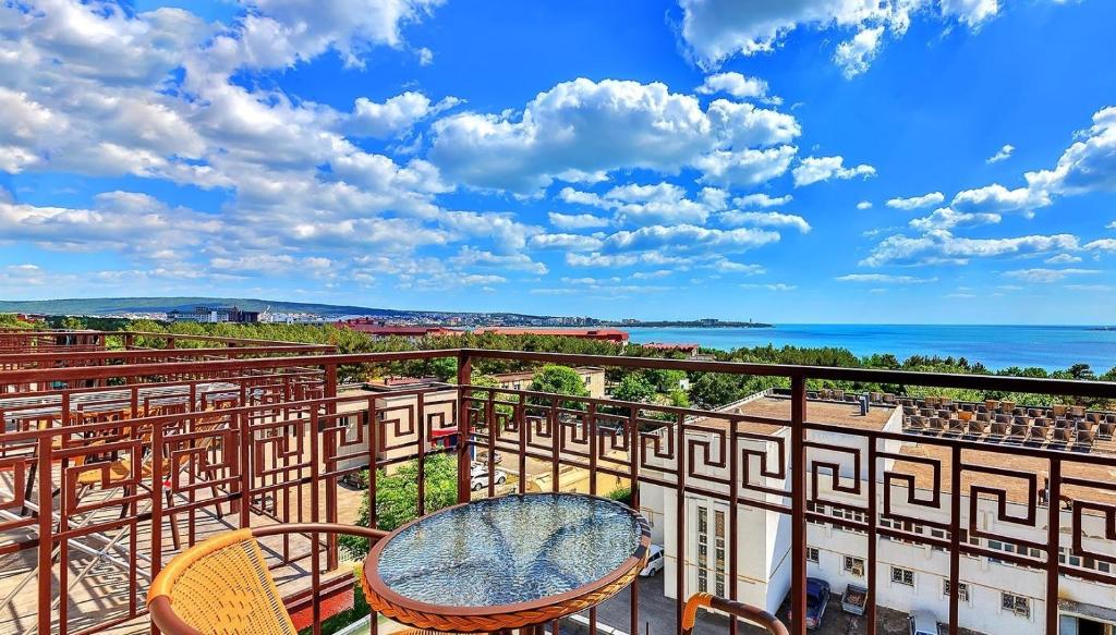 a balcony with a table and chairs and the ocean at CaliforniaHotel in Gelendzhik