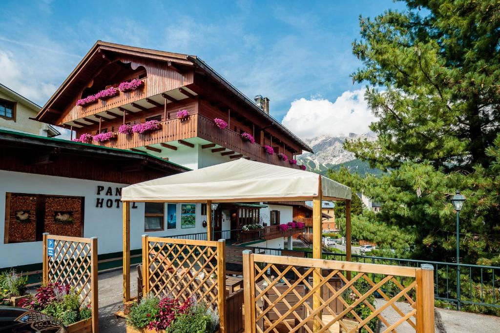 um edifício com uma tenda em frente em Hotel Panda Cortina- ricarica auto elettriche em Cortina dʼAmpezzo