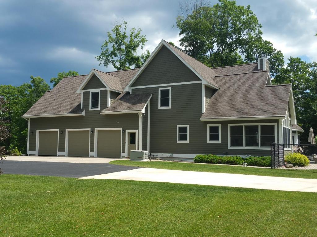 a house with a gray house with a garage at Elegant 2 King Bedrooms Apartment - 4 guest maximum and2 night minimum in Traverse City