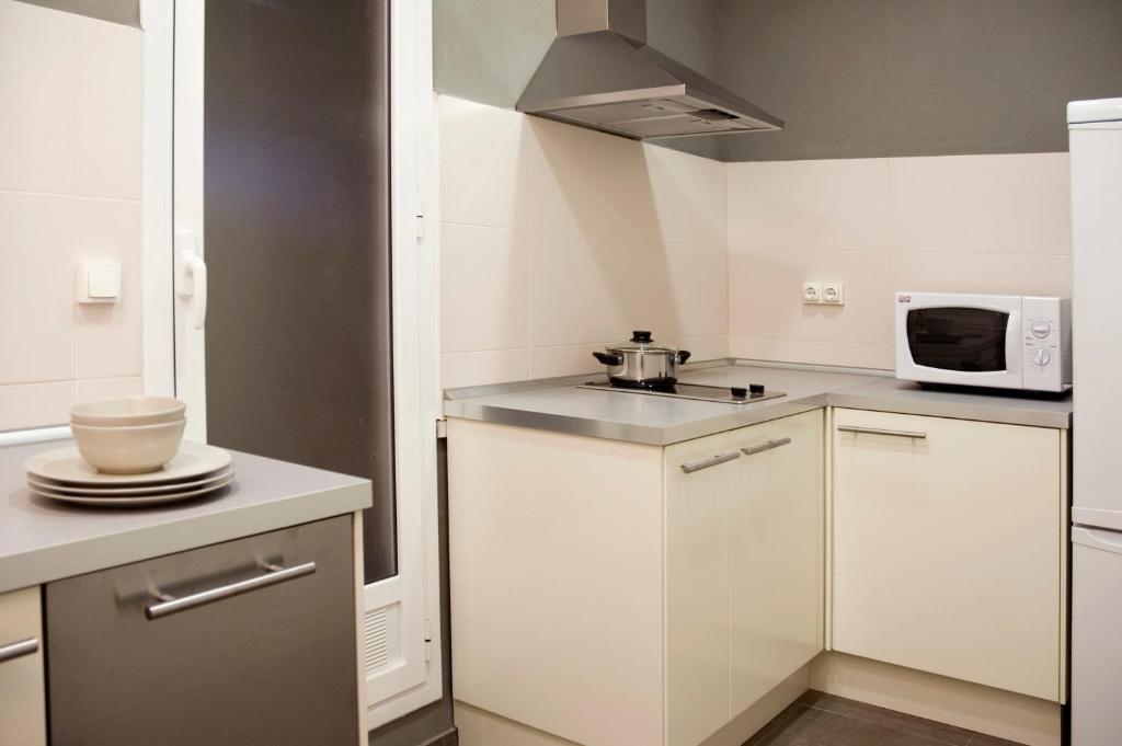 una piccola cucina con armadietti bianchi e forno a microonde di Barcelonaguest a Barcellona