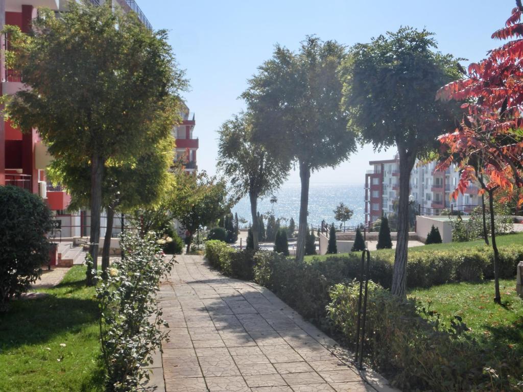 スヴェティ・ヴラスにあるApartment Panorama on complex with pools and beach, Sveti Vlasの木々や建物が並ぶ公園内の散歩道