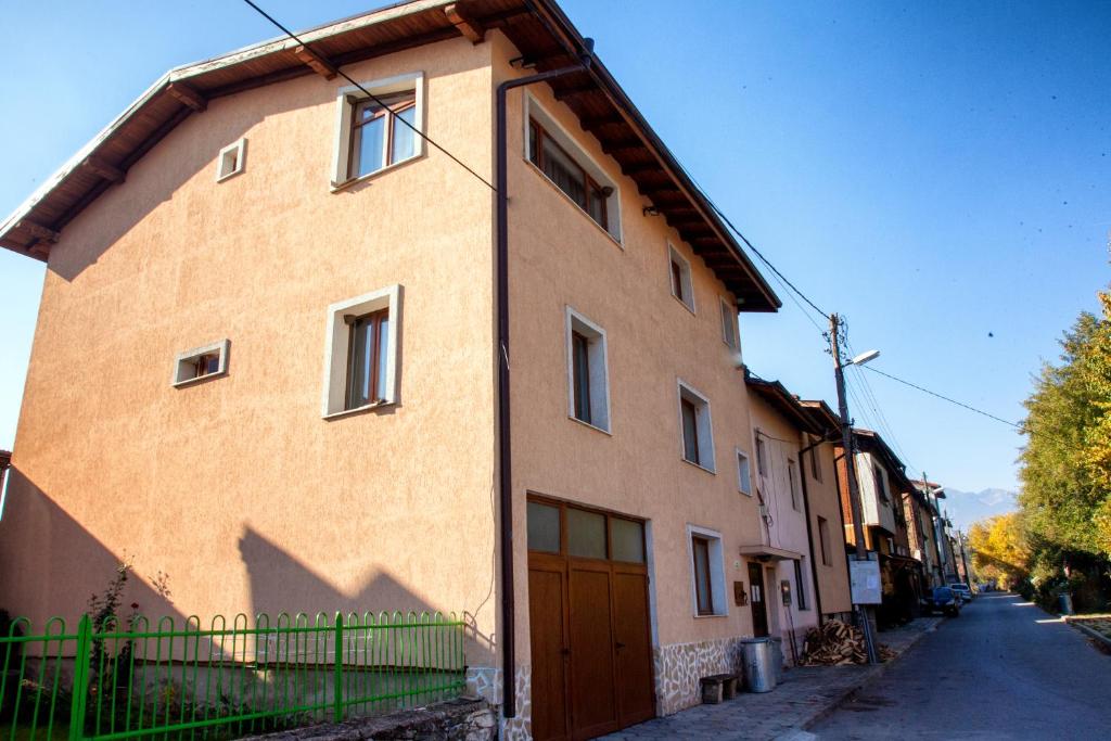 ein großes Backsteingebäude mit einer Holztür auf einer Straße in der Unterkunft Valevitsata Guesthouse in Raslog