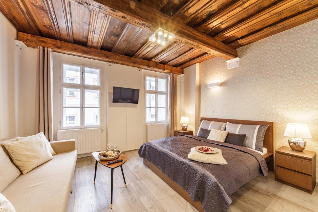een slaapkamer met een groot bed en een bank bij Downtown Royal Apartments in České Budějovice